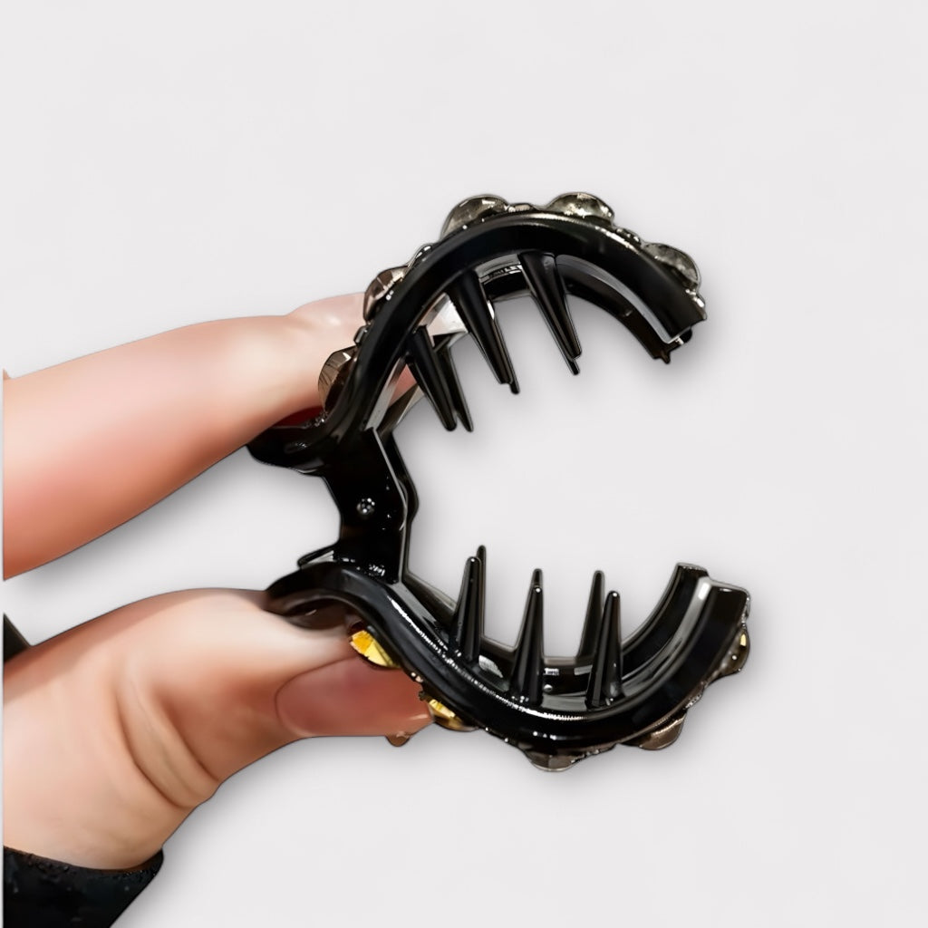 Open claw clip showing interior grip teeth, held in hand