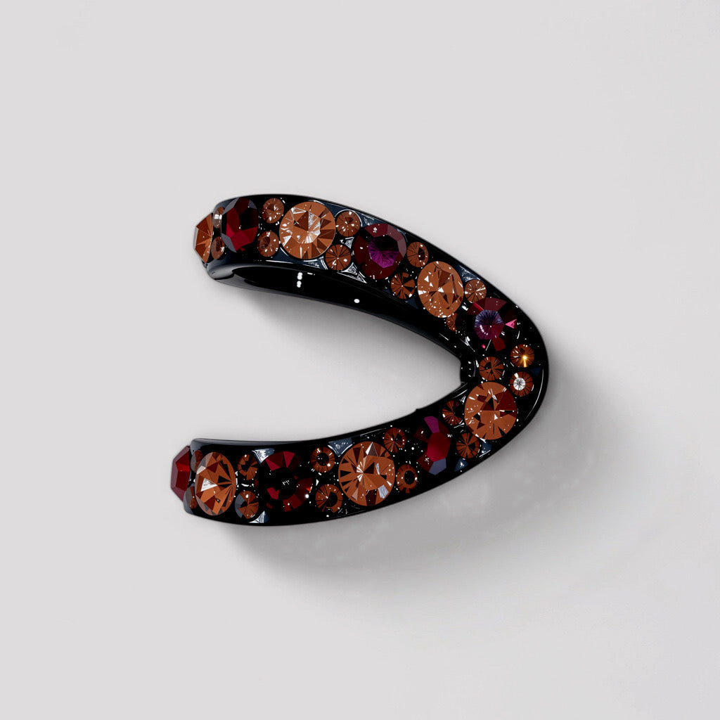 Crescent-shaped black hair claw adorned with red and pink crystals, viewed from the top