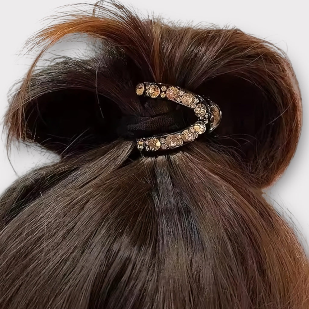 Crystal hair claw securing a casual updo on brown hair.