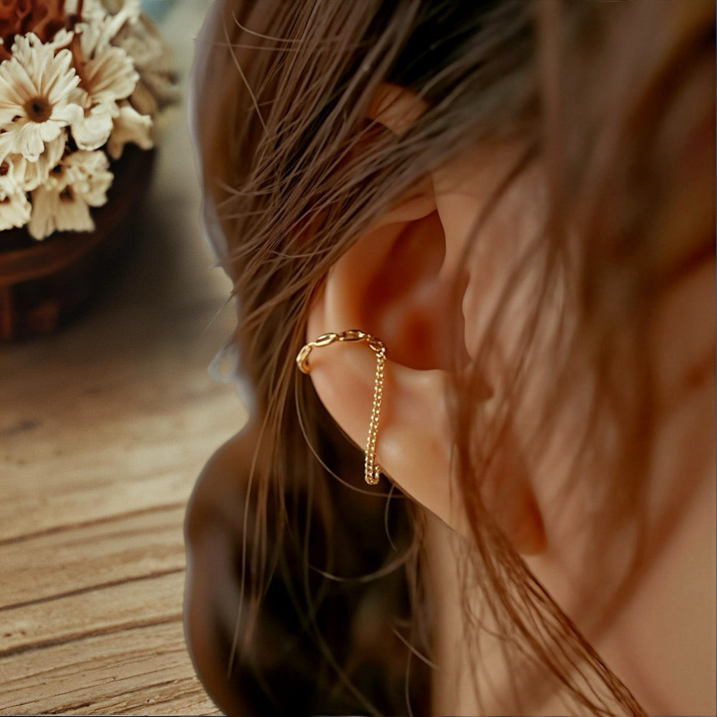 Close-up of Embrace Cuff Chain Earrings on ear, sterling silver with 18k gold plating and delicate chain