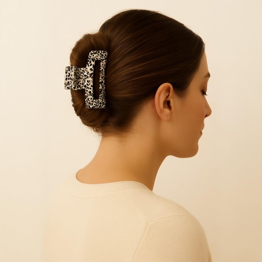 Brunette model with smooth updo wearing Ivory Eclipse animal print hair claw.