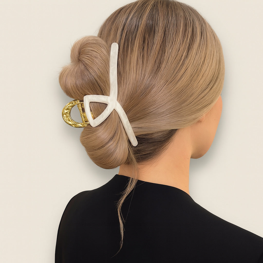 Blonde model with elegant bun wearing ivory and gold pearl hair claw clip.