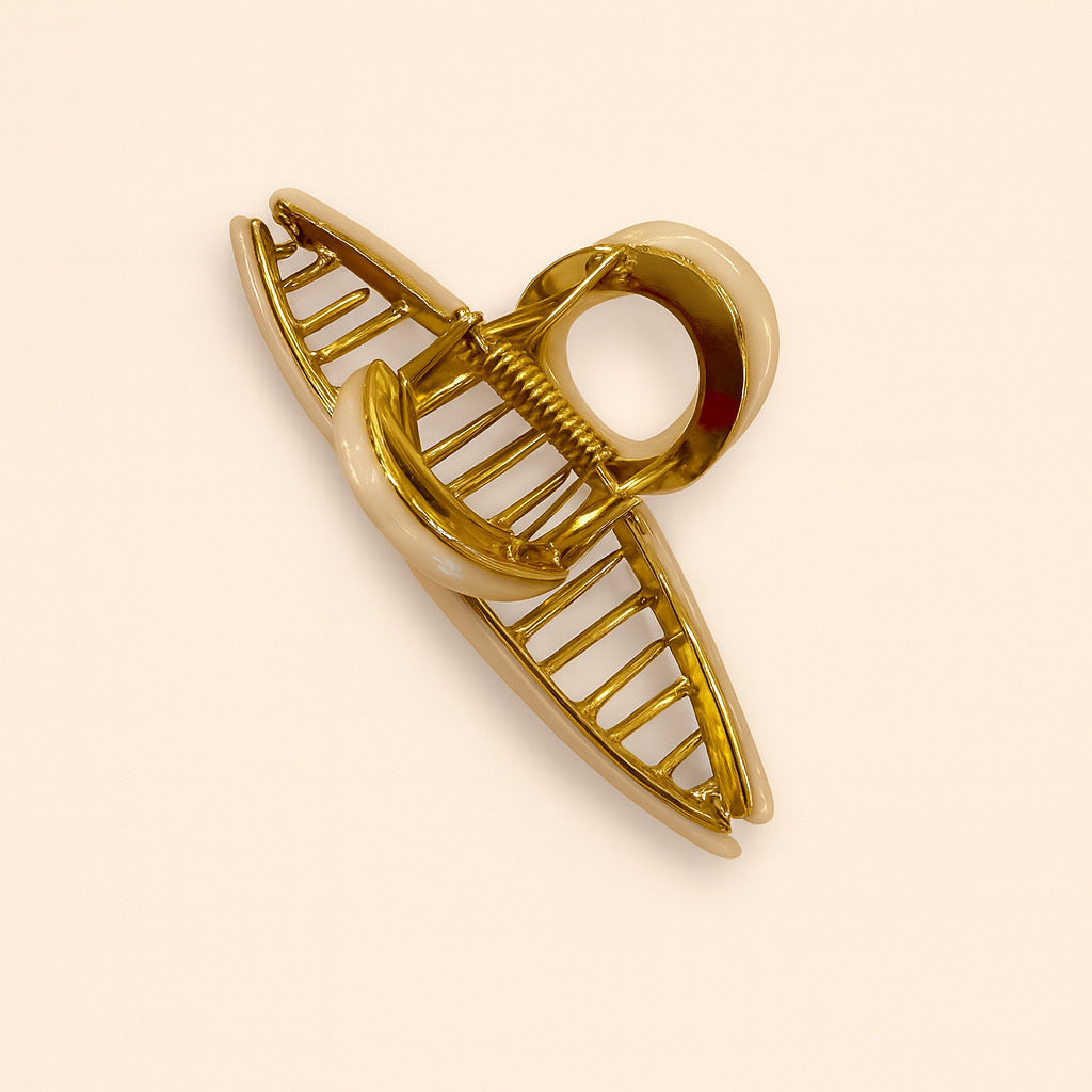 Gold accented hair claw clip in pearlescent white acrylic, shown open from a top-down perspective.