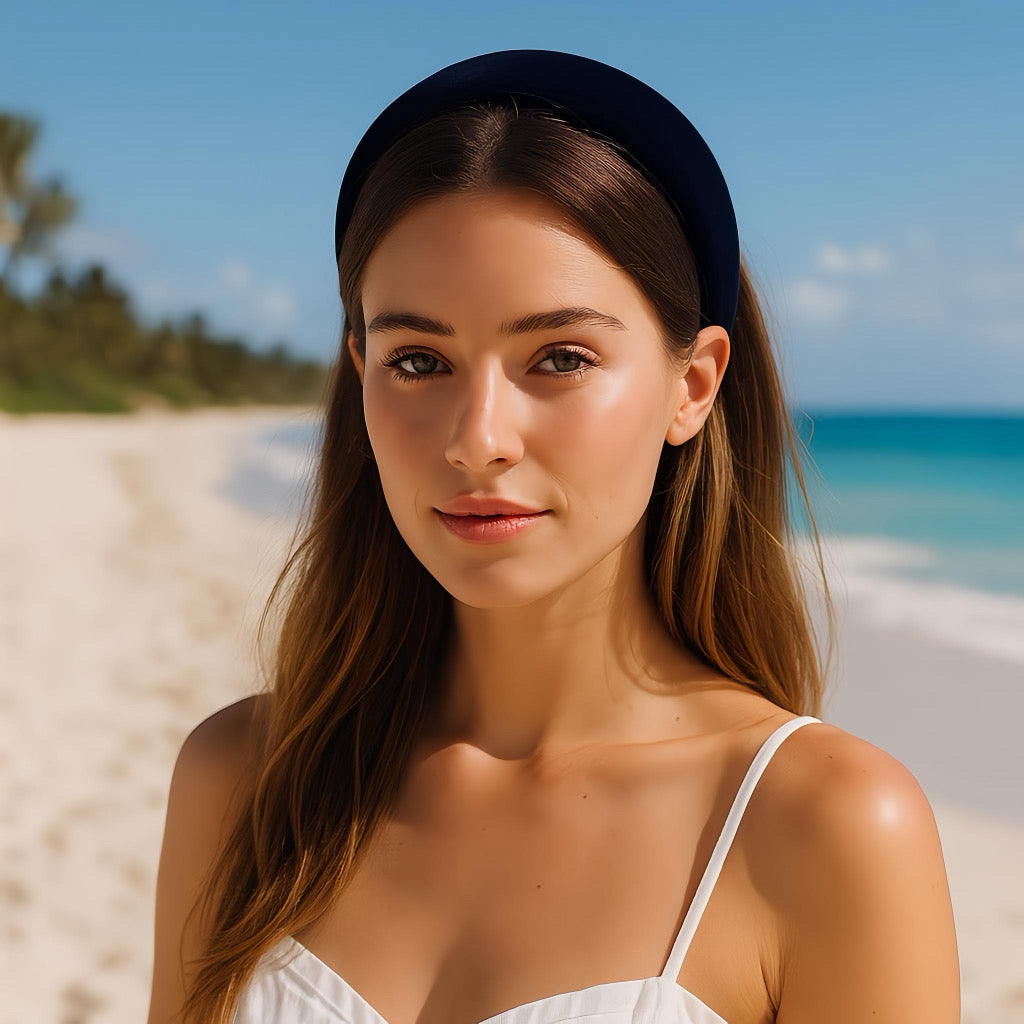Pretty model wearing a navy-blue velvet headband during summer holiday by the beach.