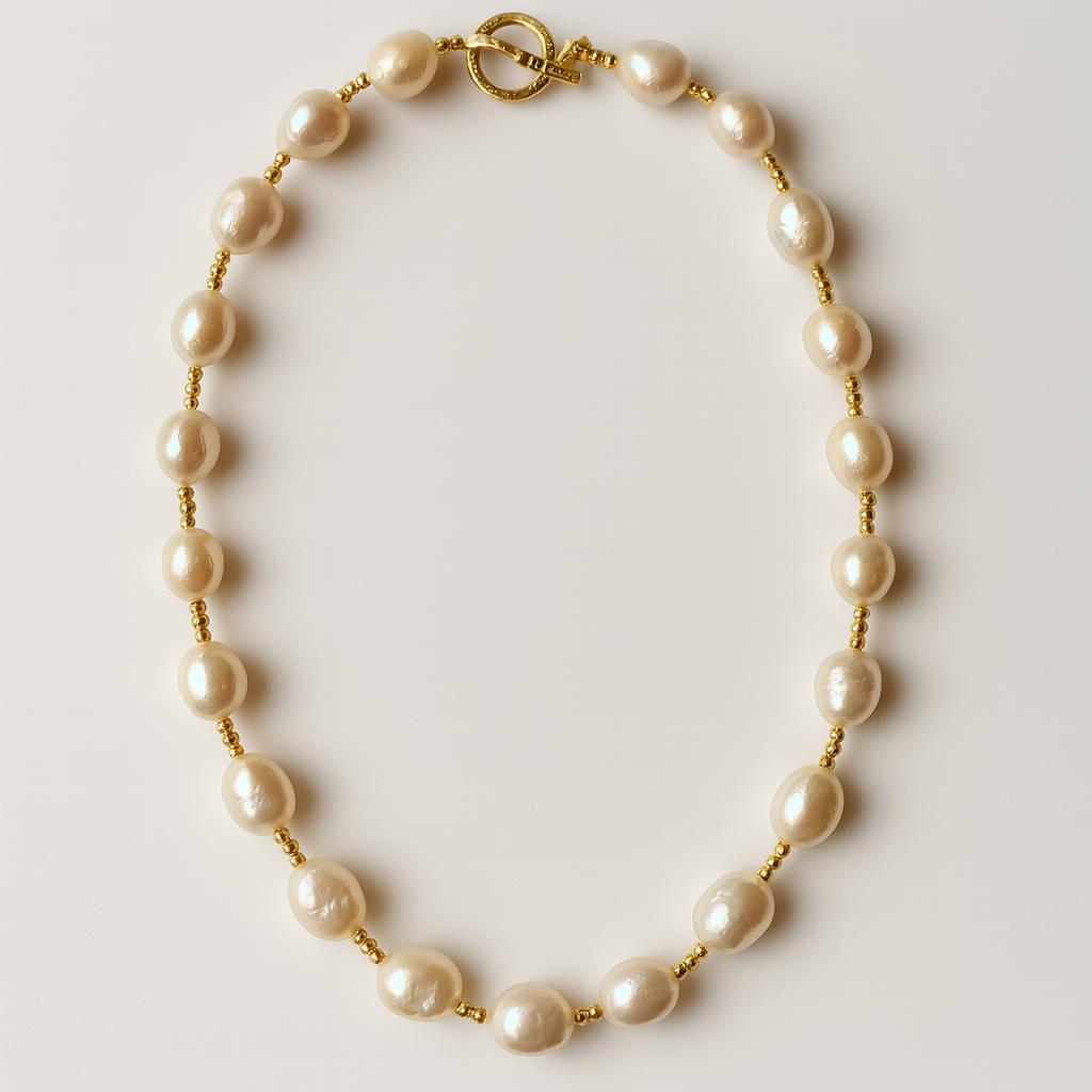 Detailed view of PaulaB Golden Pearl Elegance Necklace with polished freshwater pearls and gold beads.