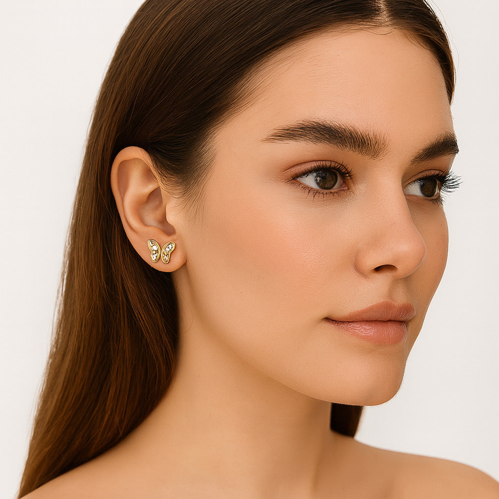 Model wearing PaulaB 14k gold plated butterfly stud earrings, elegant and feminine design.