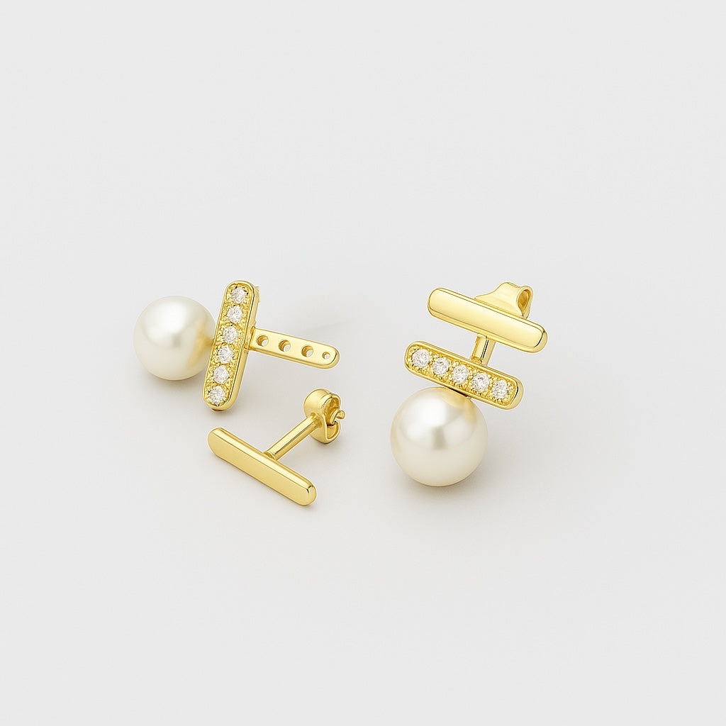 Pair of PaulaB gold plated sterling silver pearl earrings on #ECECEC background.
