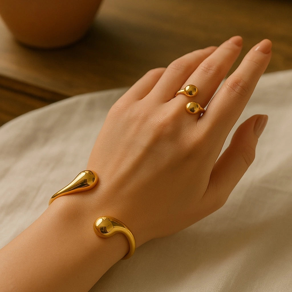 PaulaB Jewellery 18k gold cuff and ring set on model hand, minimalist luxury design with mirror-polished finish, photographed in warm natural light for Australian and New Zealand fashion lovers. 
