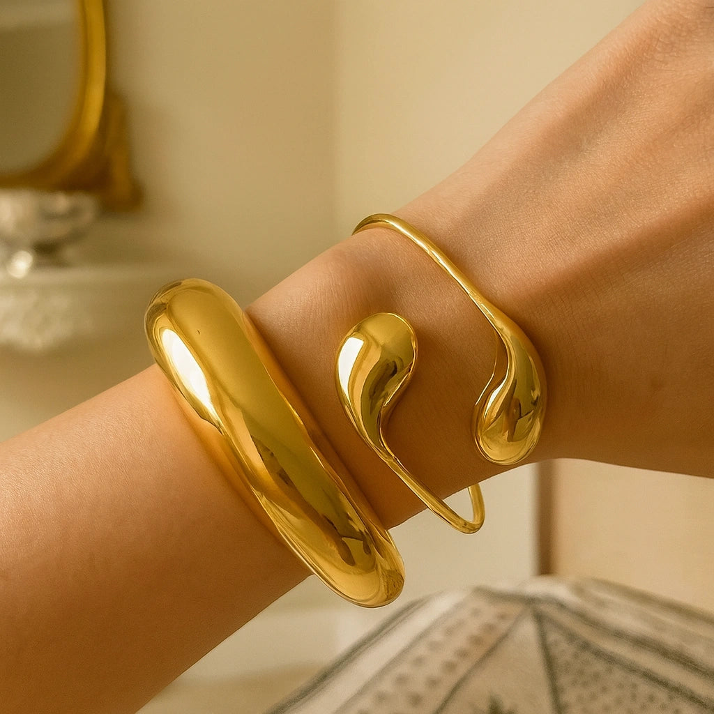 PaulaB Jewellery 18k gold polished cuff bracelet stacked with bold bangle on wrist, minimalist luxury design photographed in warm natural light for Austrlin and New Zealand fashion lovers.  
