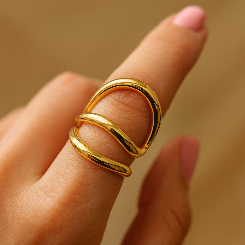 Elegant PaulaB 18k gold-plated stainless-steel ring on model's hand - close-up detail showing shine and curve design. 