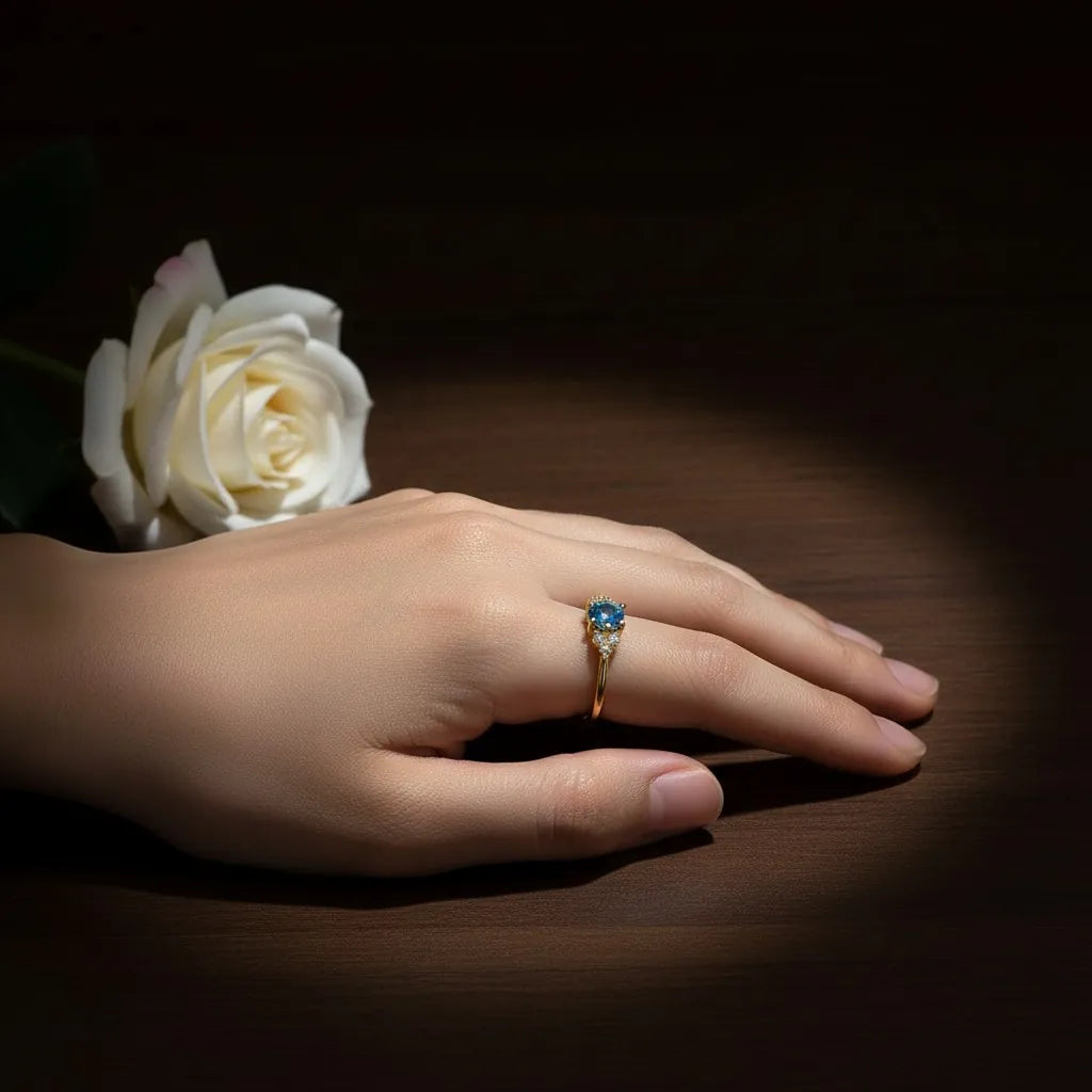 Gold ring with blue gemstone in romantic lifestyle setting with rose - PaulaB Jewellery Australia NZ UK.
