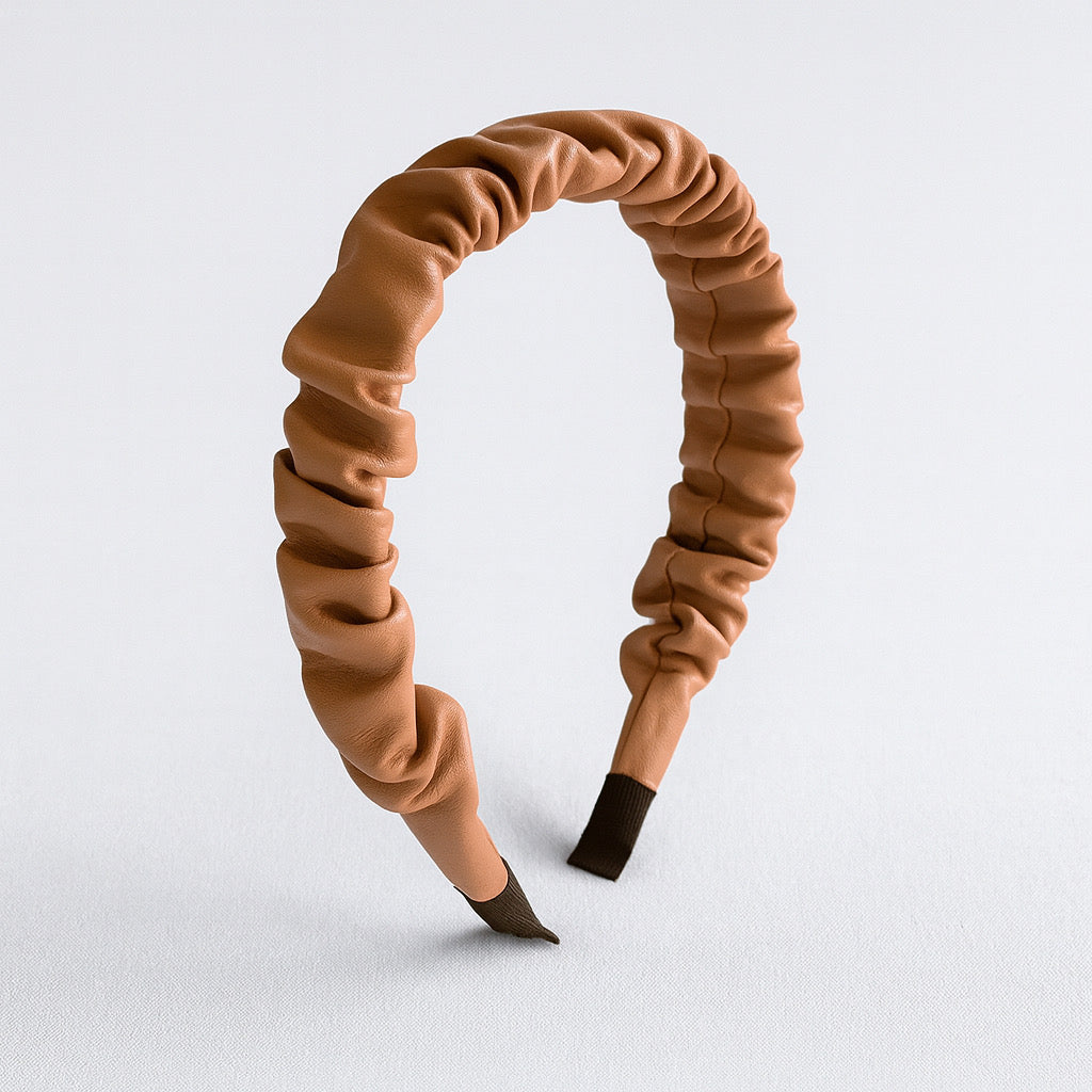 Side angle of PaulaB brown ruched PU leather headband, modern hair accessory.