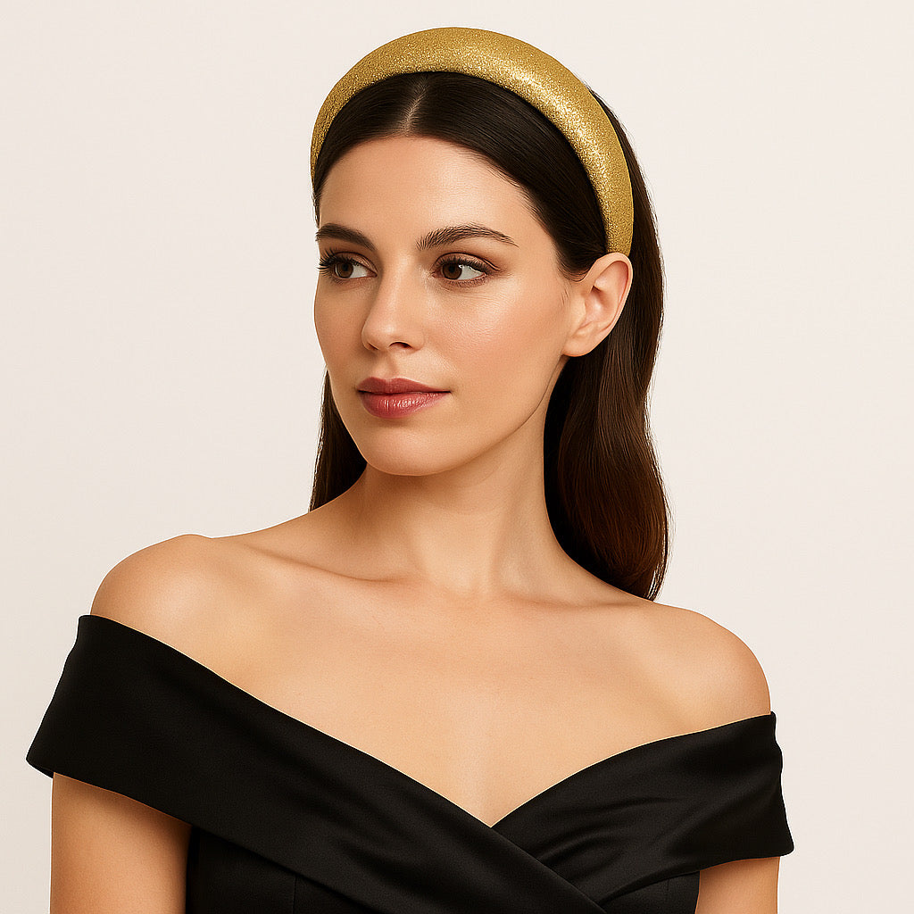 Model wearing PaulaB gold glitter headband in studio, elegant women's fashion.