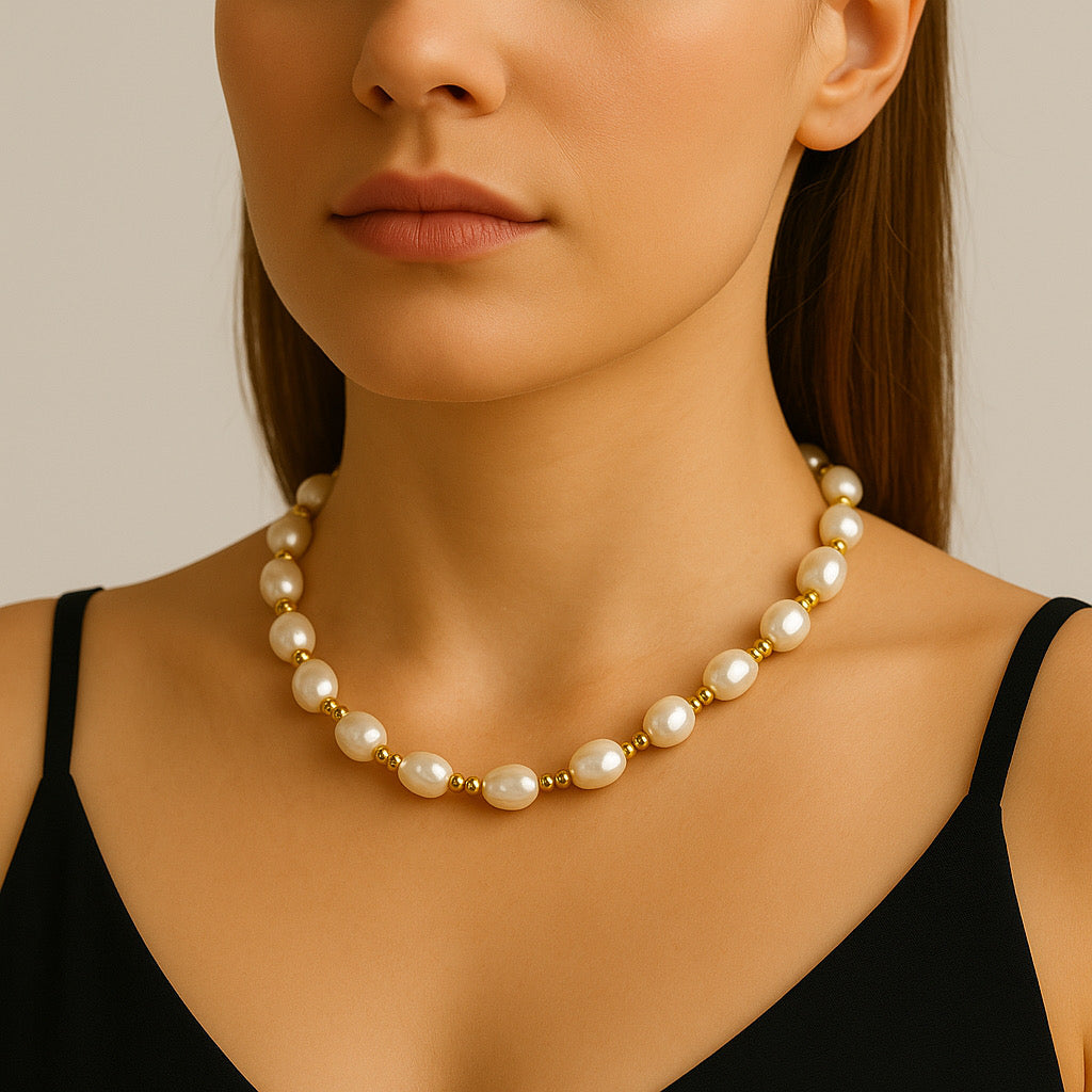 Close-up of PaulaB Golden Pearl Elegance Necklace on model in black top.