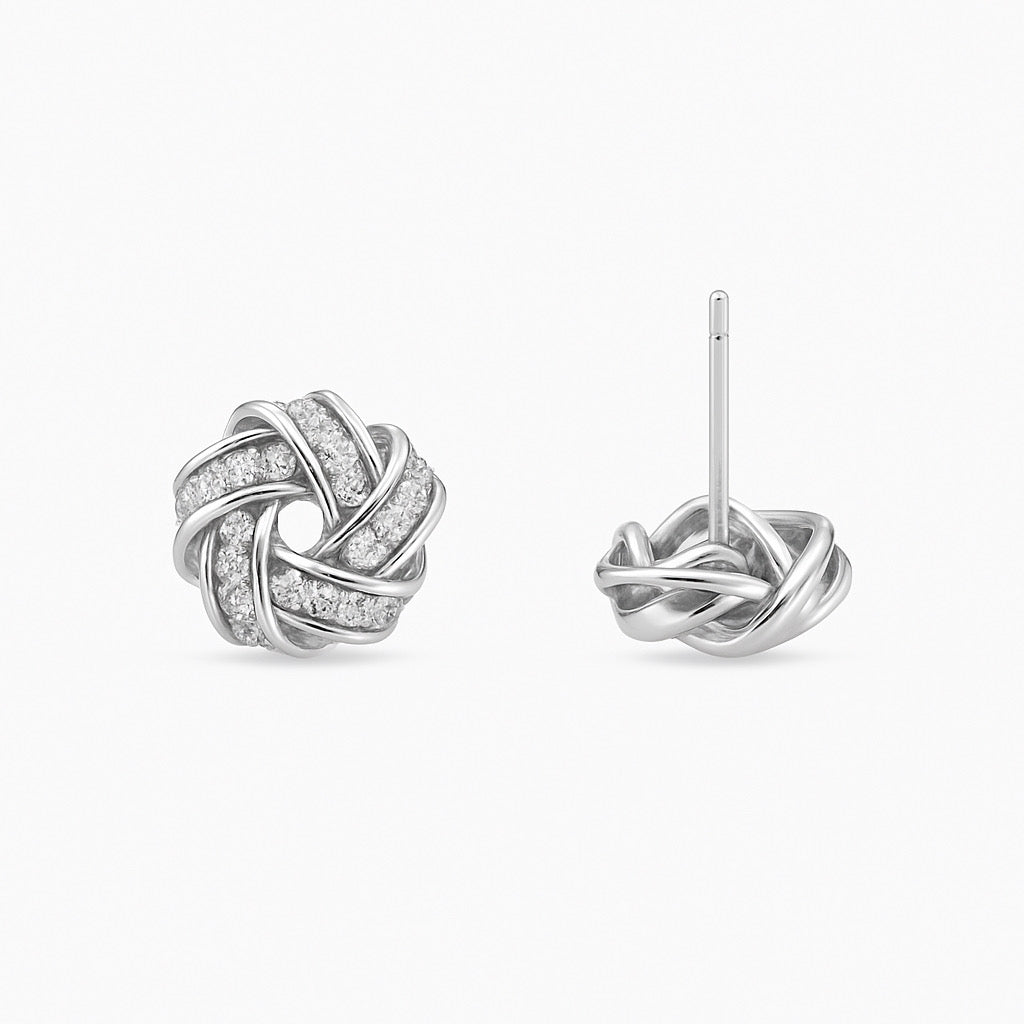 Rhodium silver love-knot pave zircon studs, 1cm, evenly spaced on light grey background.