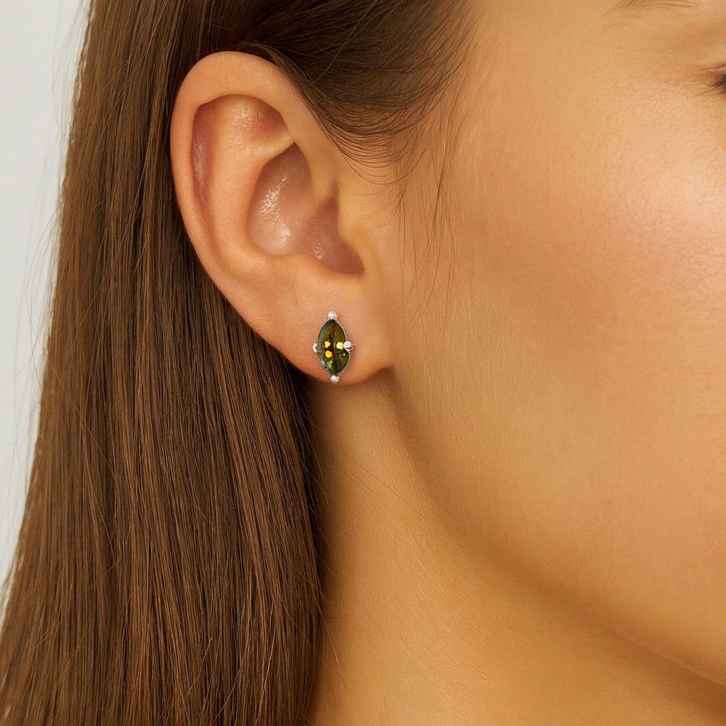 Close-up of young woman wearing PaulaB sterling silver rhodium emerald stud earrings, elegant and minimalist style Sydney.