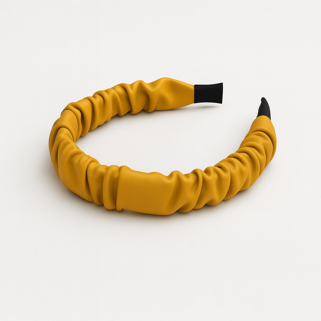 Mustard yellow PaulaB PU leather ruched headband flat lay side angle on white background, showcasing details and premium finish.