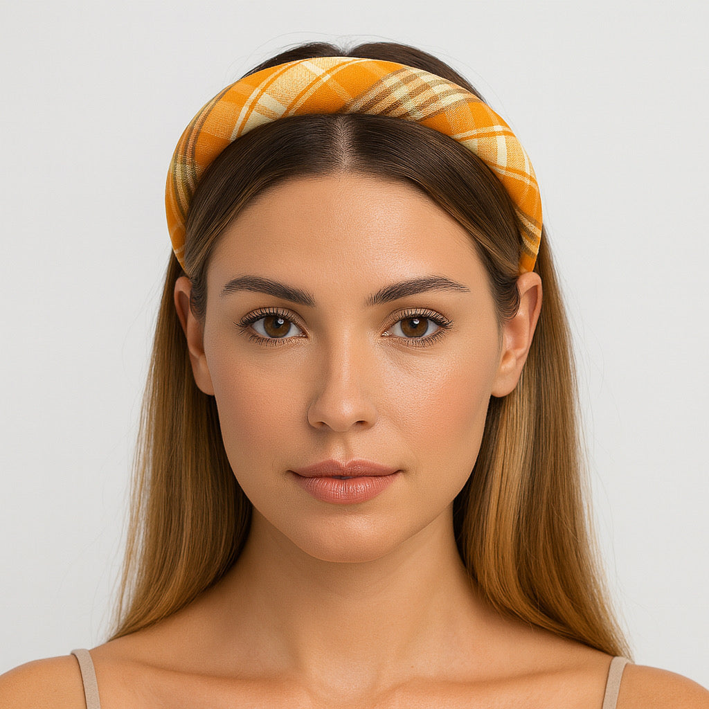 Close up studio portrait of model wearing PaulaB orange plaid polyester padded headband