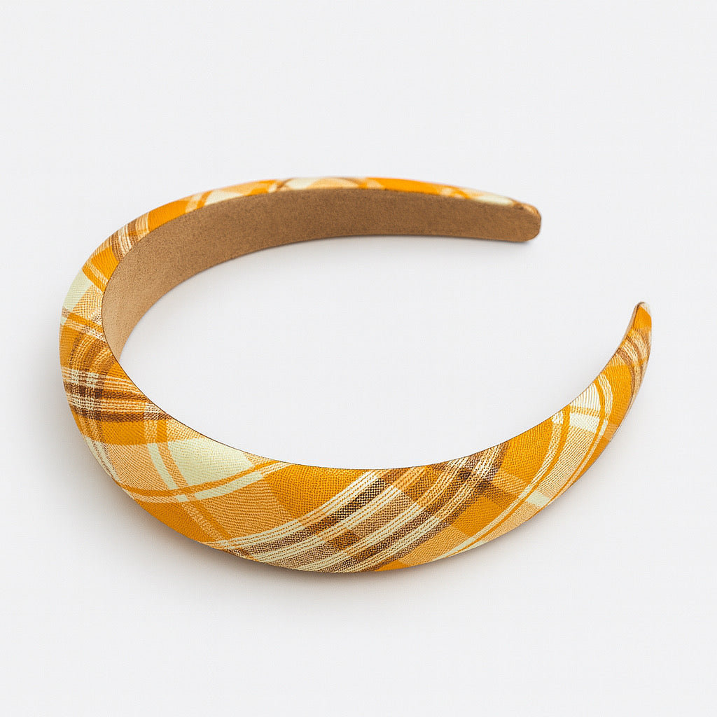 Side angle view of PaulaB orange plaid padded headband in polyester fabric with medium cushion