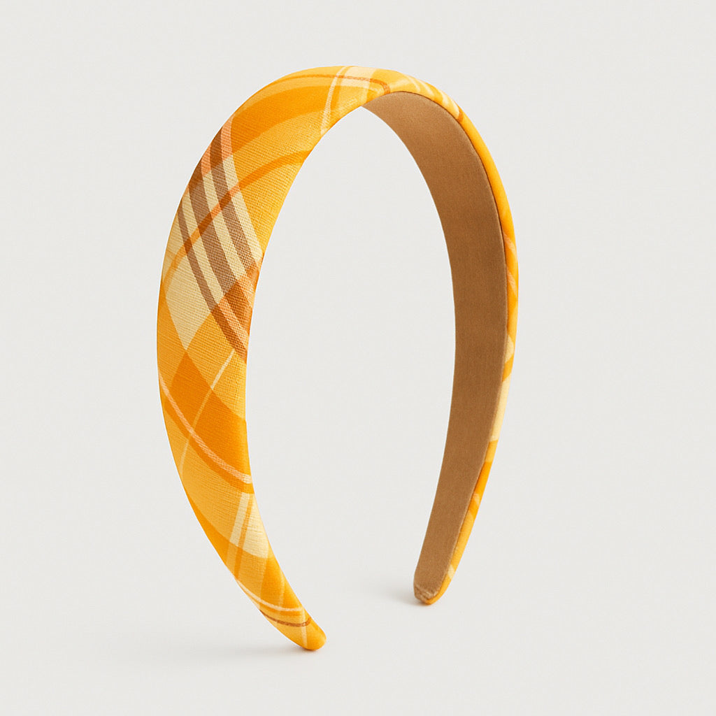 Standing profile display of PaulaB handmade orange plaid polyester headband medium cushion