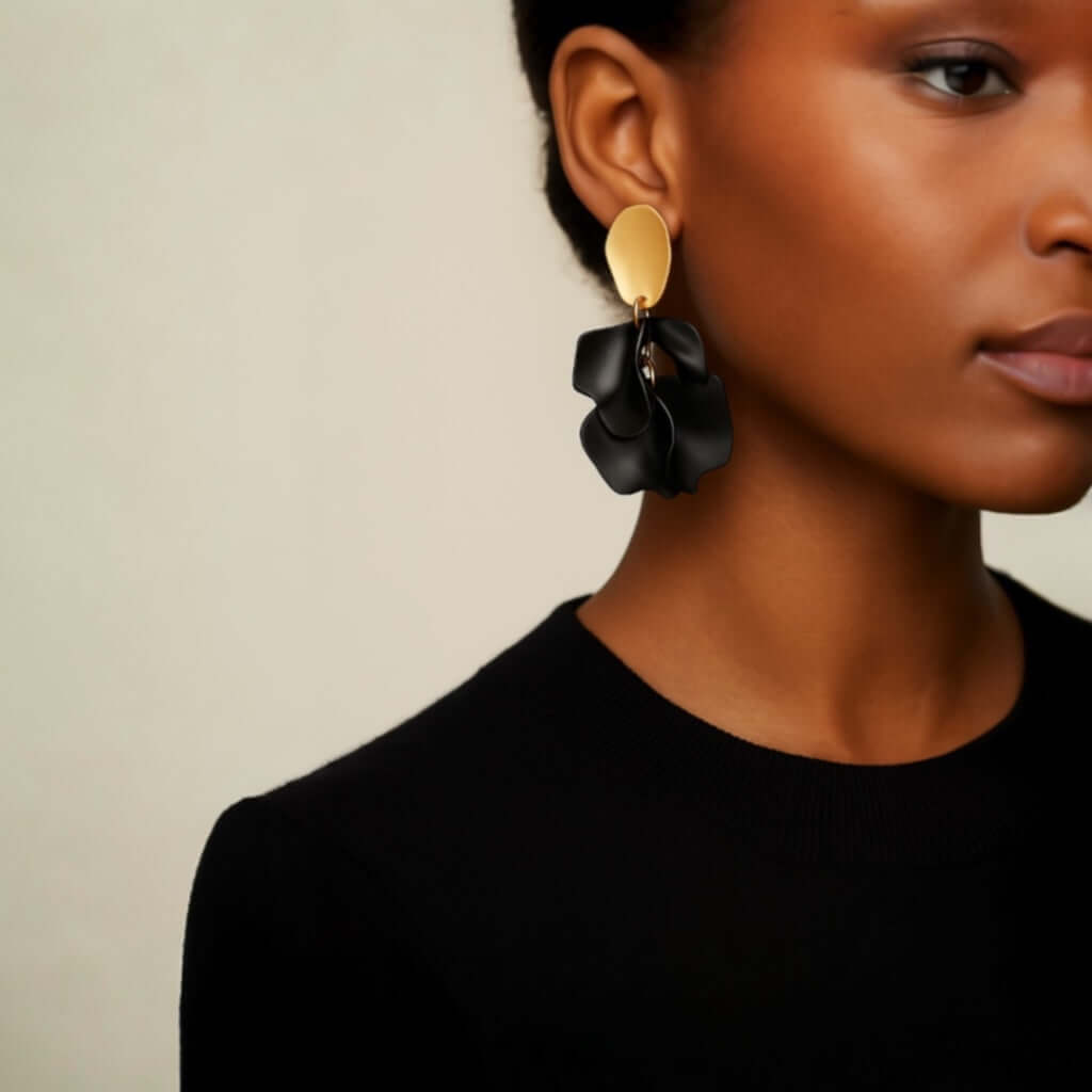 Model wearing black petal statement earrings.