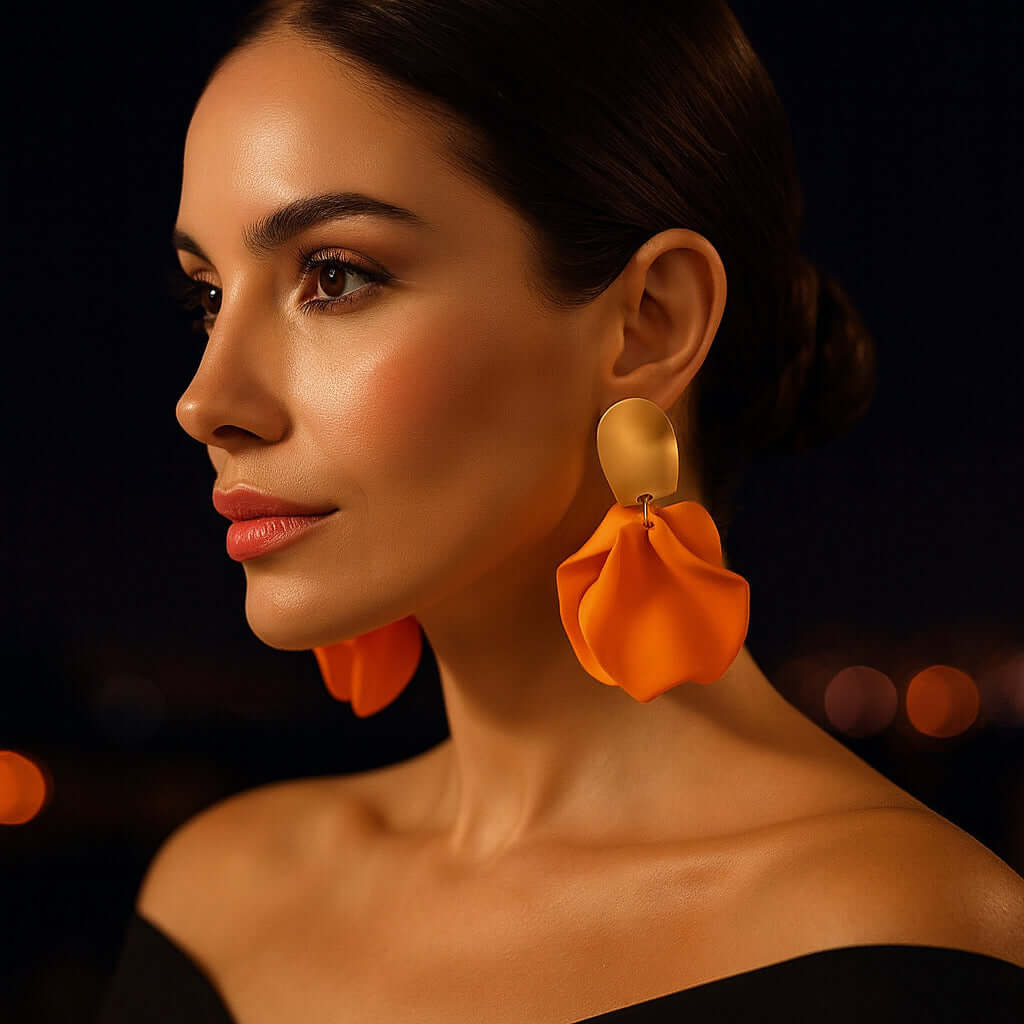 Model wearing orange petal statement earrings in an evening setting.
