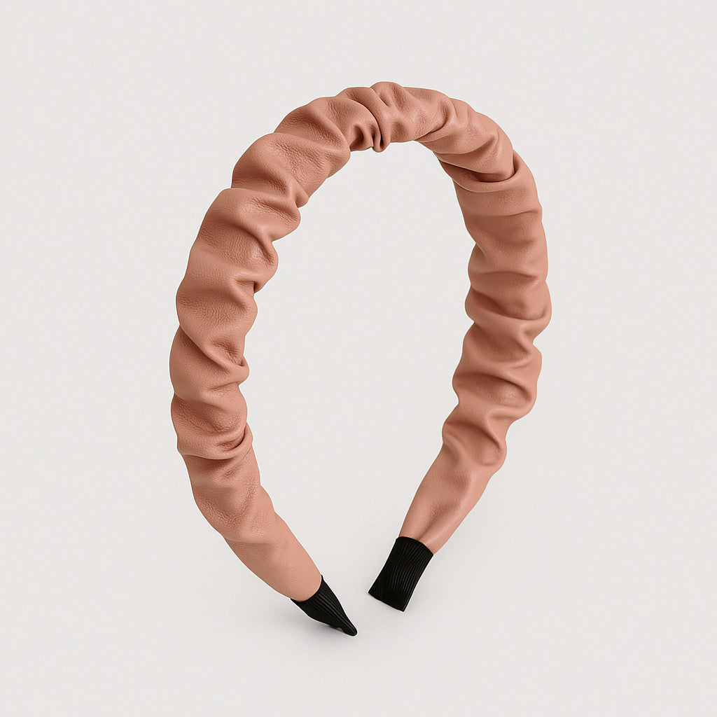 Curved display of PaulaB pink PU leather headband showing ruched design.