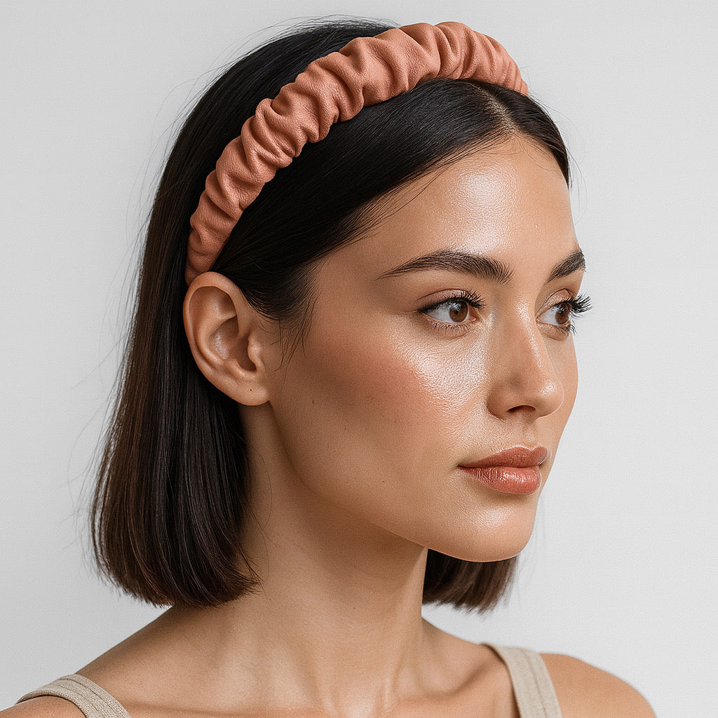 Close-upside profile of model wearing PaulaB pink PU leather headband in studio.