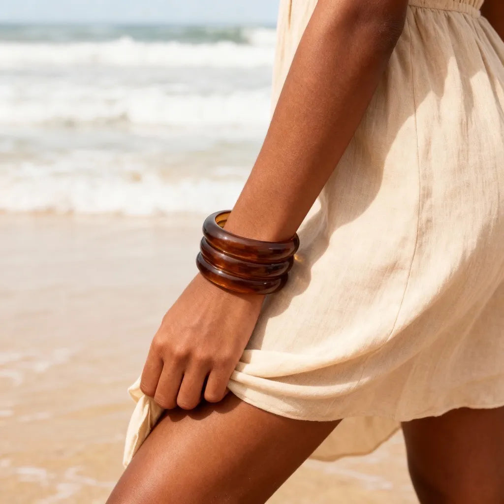 Amber resin cuff bracelet styled on model at the beach, PaulaB lifestyle photo for summer fashion in Australia, NZ and UK.
