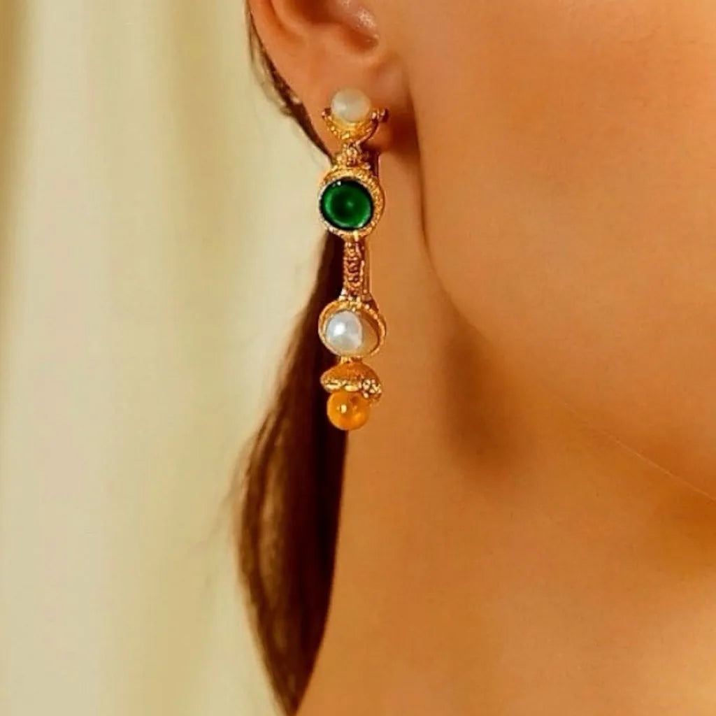 Model wearing PaulaB 18k gold hoop earrings featuring pearls, green and yellow gemstones. Stylish statement earrings available in Australia, NZ and the UK.
