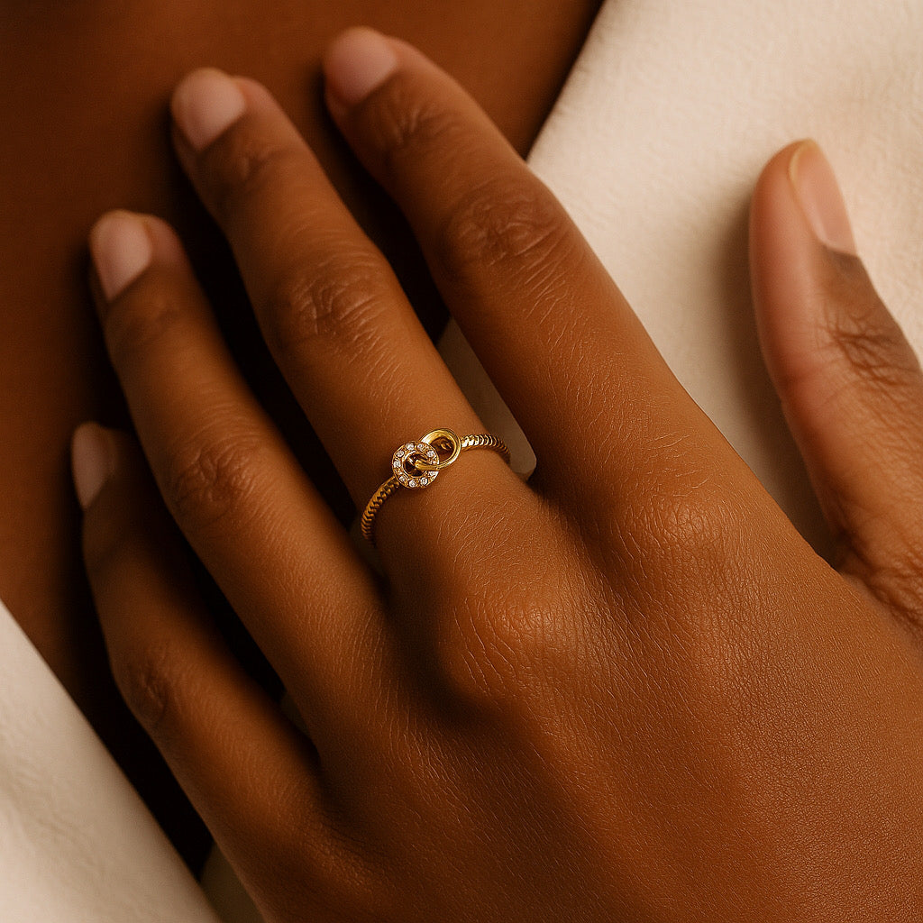 Lifestyle hand shot of PaulaB sterling silver adjustable knot ring 14k gold plated.