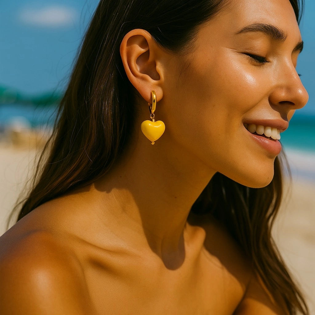 Sunshine Yellow Heart Earrings on model at the beach - PaulaB Jewellery Australia - 14k Gold plated Ceramic Heart Earrings.