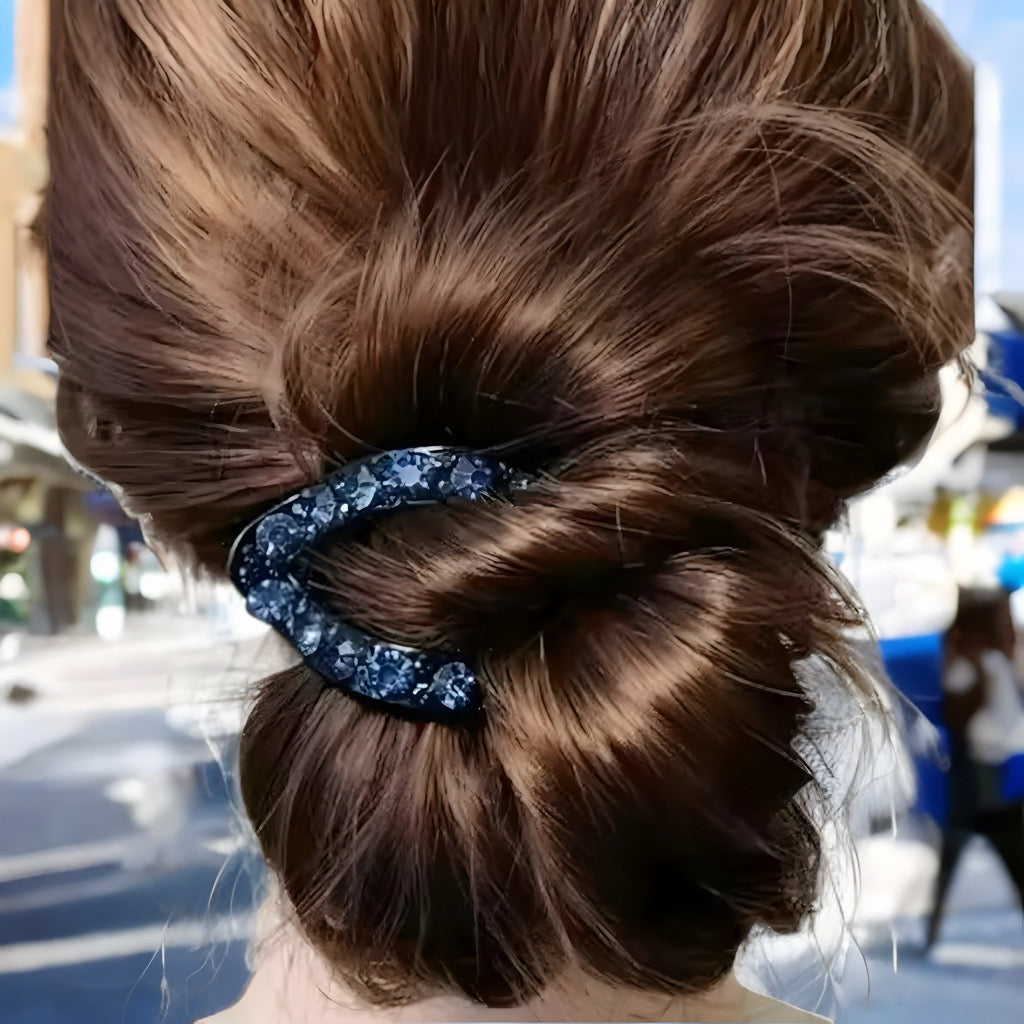 Hair claw with sapphire blue rhinestones styled in brown updo.