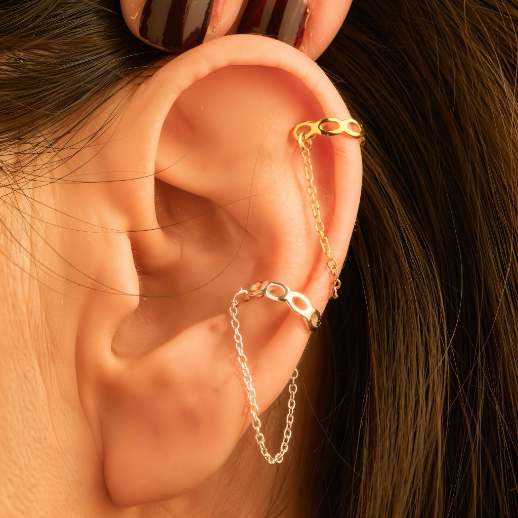 Close-up of sterling silver cuff chain earrings on ear with delicate connecting chain