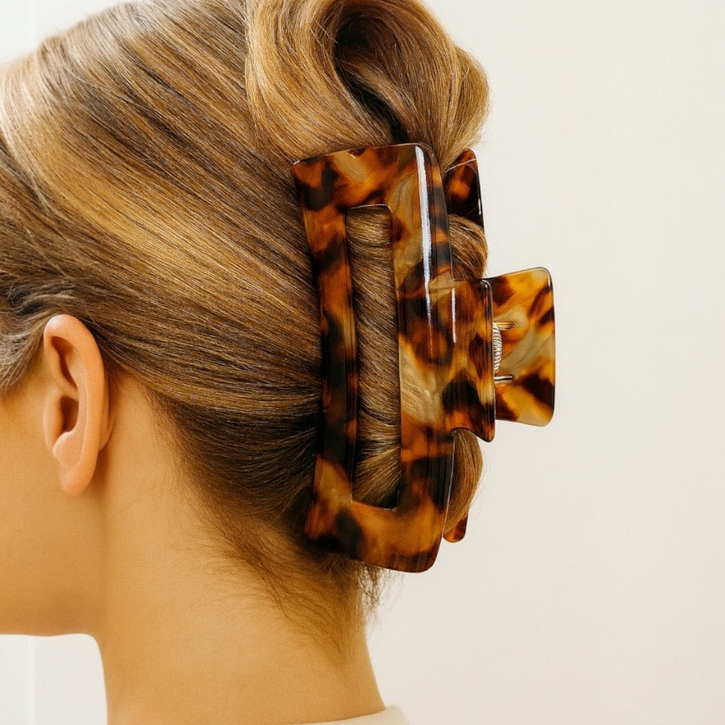 Model with blonde updo wearing tortoise hair claw clip.