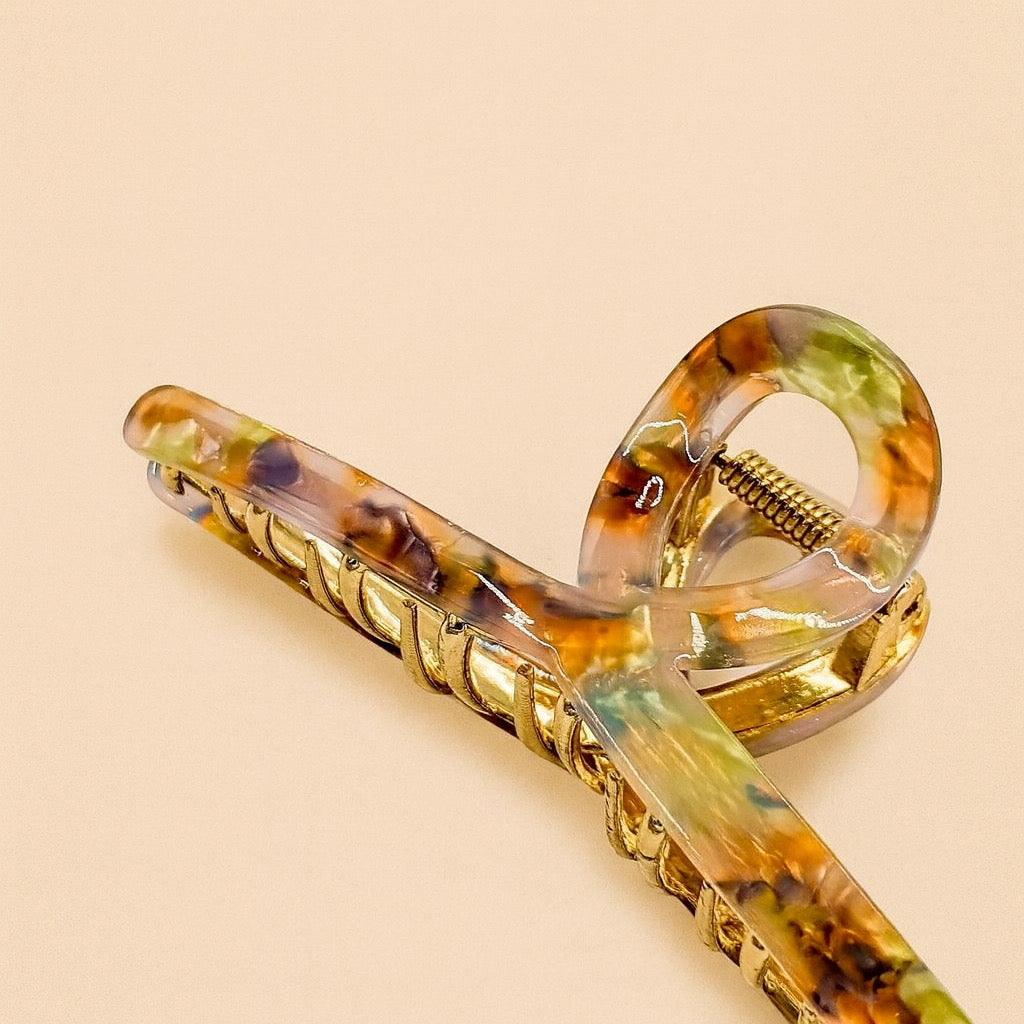 Open view of marble acrylic and gold-tone hair claw clip, showcasing the curved structure and fine gold inner detailing.